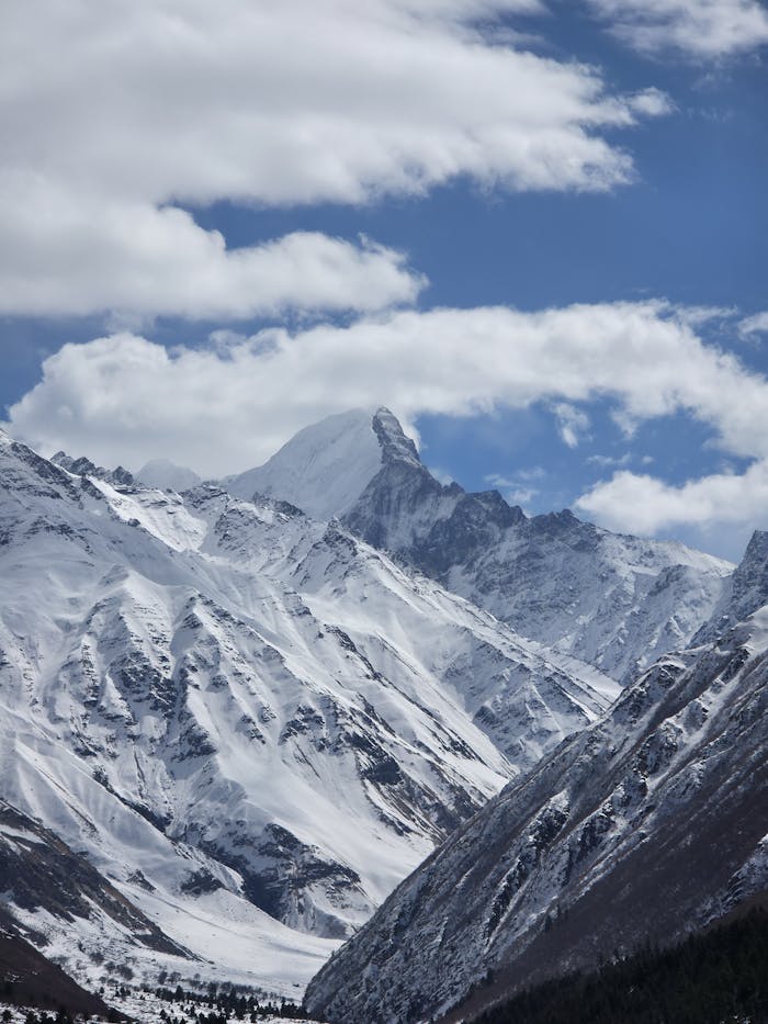 hero-img-02 Stunning snow-capped mountains of the Himalayas under a dramatic cloudy sky.