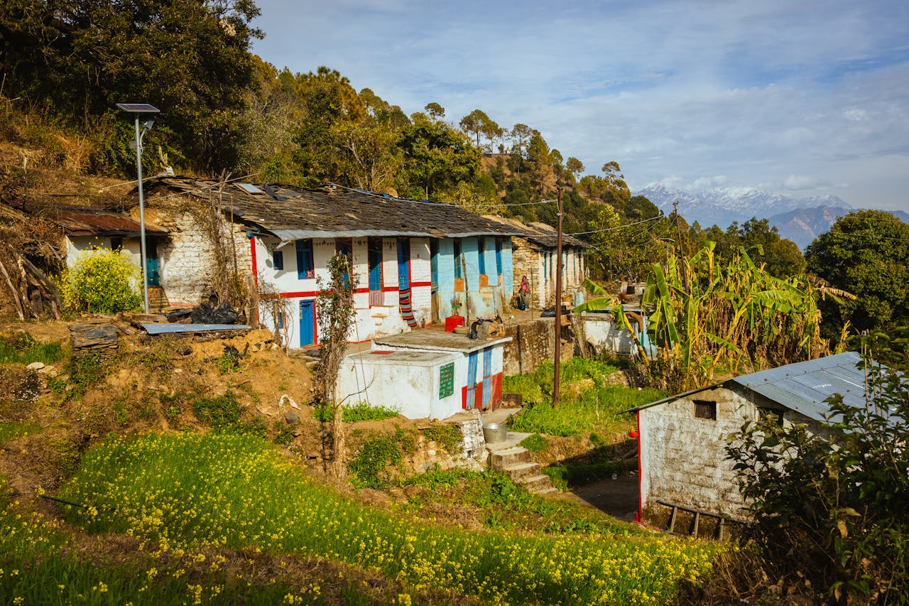 gallery-5 Picturesque village in Uttarakhand nestled in the Himalayas with traditional houses and lush greenery.