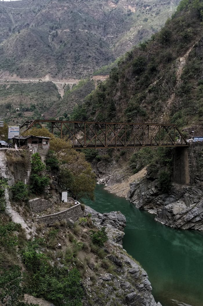 gallery-2 Explore the rustic beauty of a bridge over a river, nestled in the Himalayan mountains.